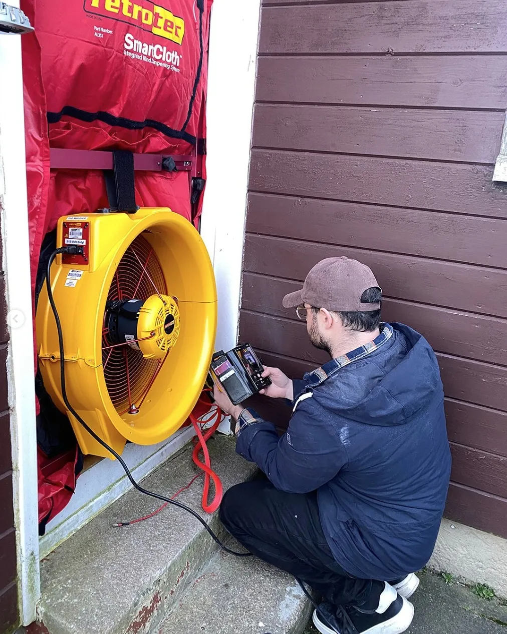 Connor Milton, founder of Kanna, conducting airtightness testing on site